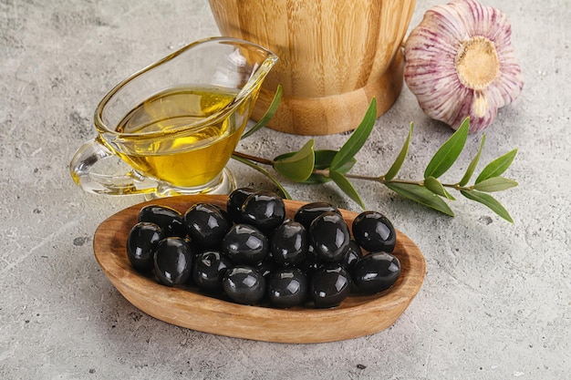 Olives noires avec de l'huile et des branches