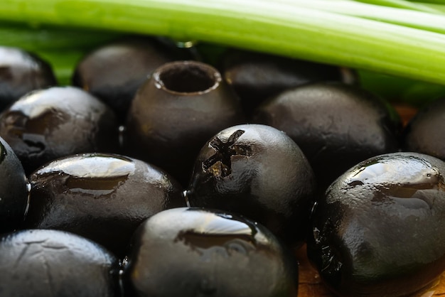 Photo olives noires marinées sur fond de bois