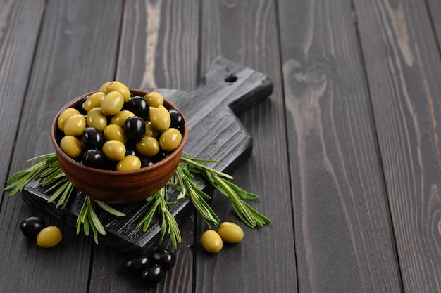 Olives noires et vertes sur un fond rustique en bois foncé