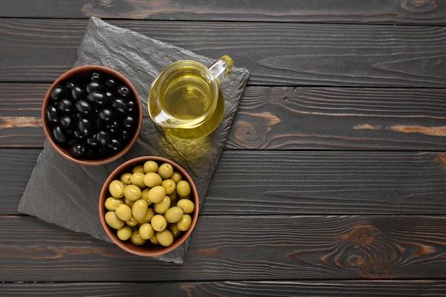 Olives noires et vertes sur un fond rustique en bois foncé