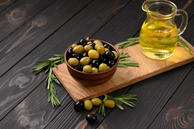 Olives noires et vertes sur un fond rustique en bois foncé