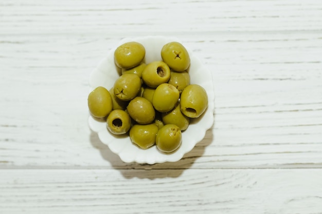 Olives vertes en conserve dans un bol blanc sur la table