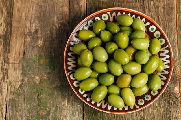 Olives vertes dans un bol brun