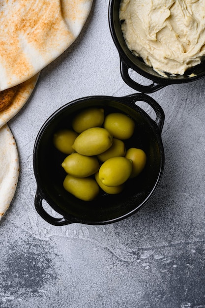 Olives vertes dans l'huile sur fond de table en pierre grise vue de dessus à plat avec espace de copie pour le texte