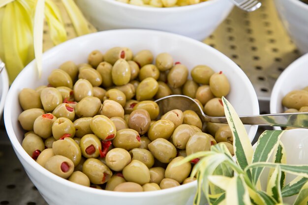 Olives vertes farcies de paprika sur une assiette.