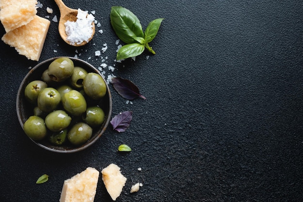 Photo olives vertes avec olives parmesan et sel sur fond sombre fond de cuisine italienne