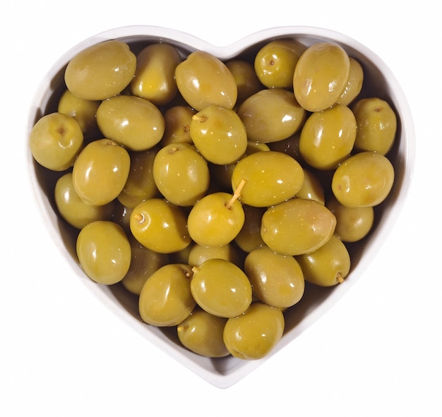 Olives vertes en plaque en forme de coeur sur fond blanc