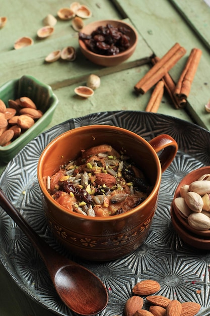 Om Ali ou Um Ali, pain traditionnel arabe ou pudding de croissant avec pistache, amande et pétale de rose comme garniture, dessert lacté et crémeux. Servi dans une tasse