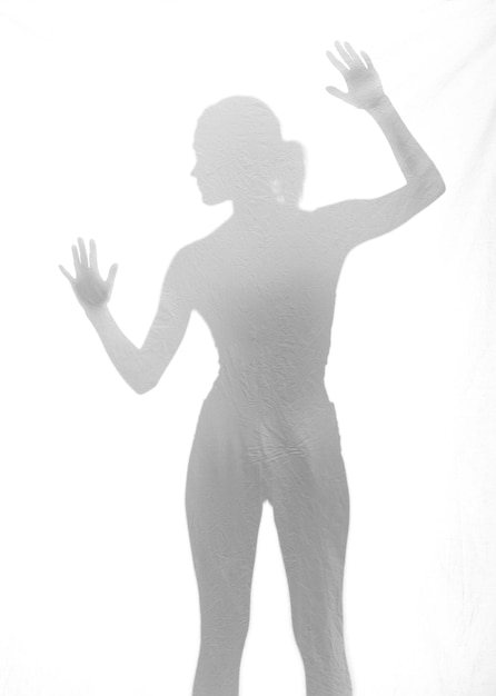 Photo l'ombre d'une femme avec les bras levés sur le mur blanc