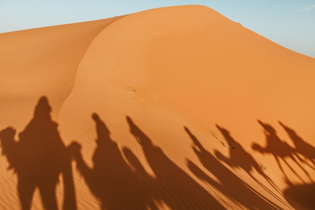 Photo l'ombre des gens sur la dune de sable