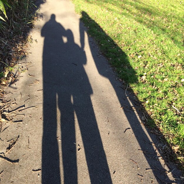 Photo l'ombre des gens sur la route par l'herbe