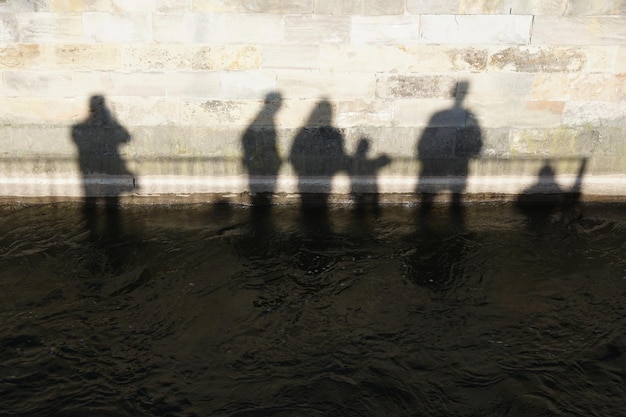 Photo l'ombre d'un groupe de personnes s'enfonçant dans des eaux sombres - être dans des eaux profondes