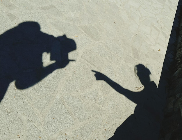 Photo l'ombre d'un homme assis sur le sable