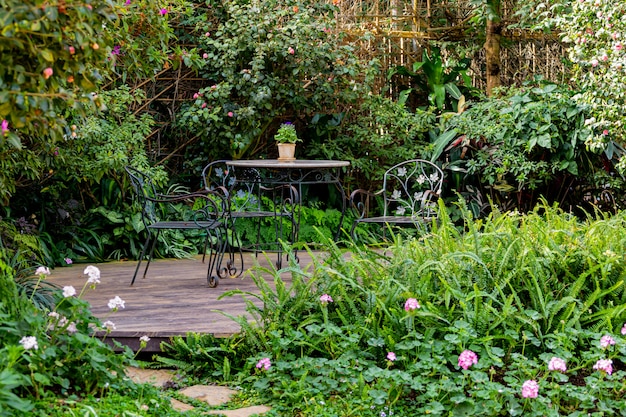 Photo l'ombre et la lumière des tables et des chaises du jardin fleuri