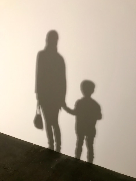 Photo l'ombre d'une mère avec son fils sur le mur