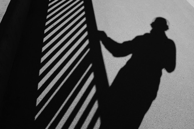 Photo ombre d'une personne et de la balustrade sur la route