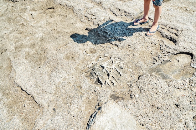 Ombre de personne de sexe masculin en short jeté sur une plage rocheuse près de la mer