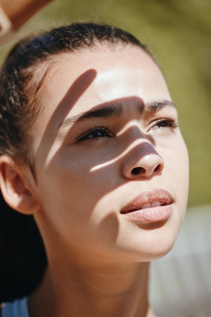 Ombre de visage et femme au soleil pour les loisirs en plein air et les vacances d'été paisibles pour le bien-être mental Belle jeune fille latino à l'extérieur pour se détendre et prendre l'air frais en couvrant les yeux de la lumière du soleil