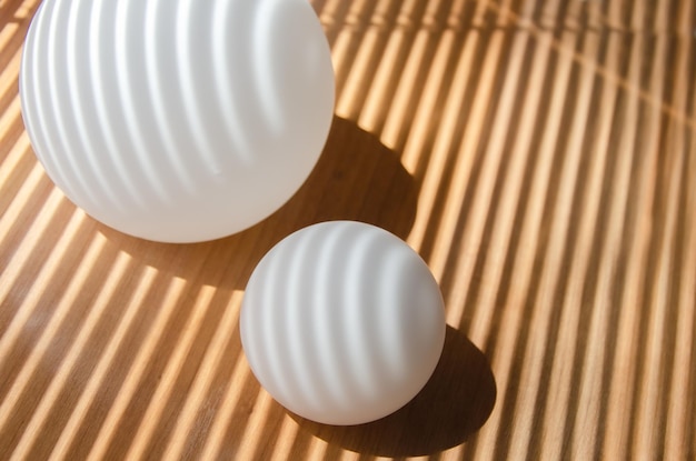 Ombres droites et courbes sur la surface sphérique des boules de verre dépoli blanc et de l'avion en bois