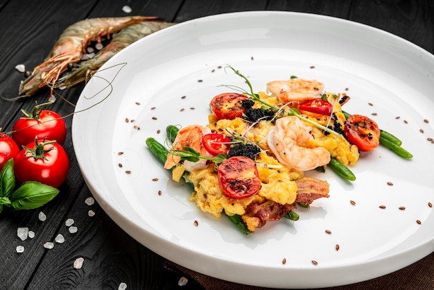 Omelette au caviar de crevettes et tomates grillées sur lit de haricots verts et bacon