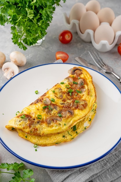 Omelette aux champignons frits et herbes fraîches sur un fond de béton Délicieux petit déjeuner sain