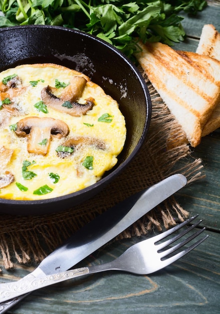 omelette aux champignons et herbes dans une poêle