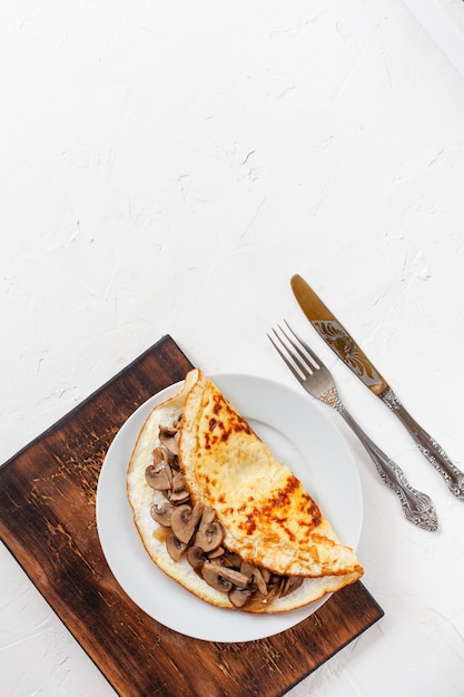 Omelette aux champignons sur une planche de bois