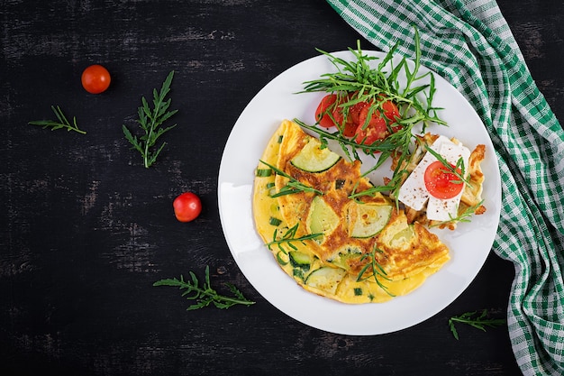 Omelette aux courgettes, herbes vertes et sandwich au fromage feta sur assiette. Frittata - omelette italienne. Vue de dessus, au-dessus, espace de copie