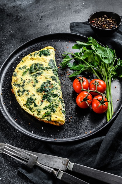 Omelette aux épinards, servie dans une assiette de tomates.