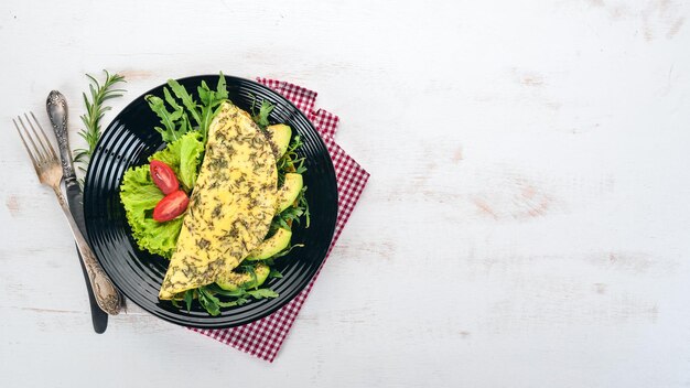 Omelette aux légumes et avocats Oeufs frits Sur un fond en bois Vue de dessus Espace de copie gratuit