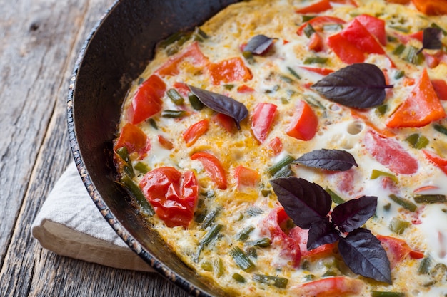 Omelette aux légumes dans un gros plan de casserole.