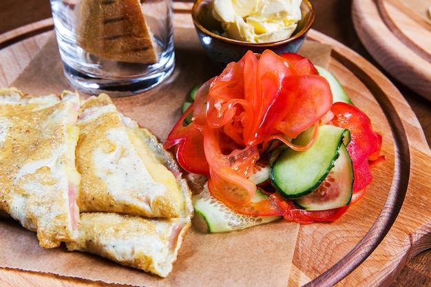 Omelette aux légumes et pain sur la table en bois du restaurant. Nourriture savoureuse. Gourmet