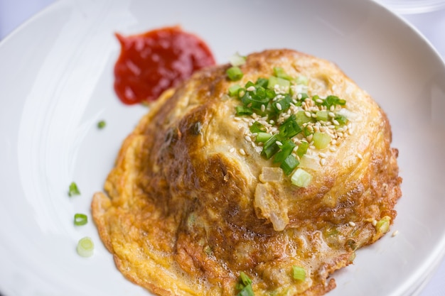 omelette aux œufs frits avec échalote et sésame blanc prêt à servir sur un plat.