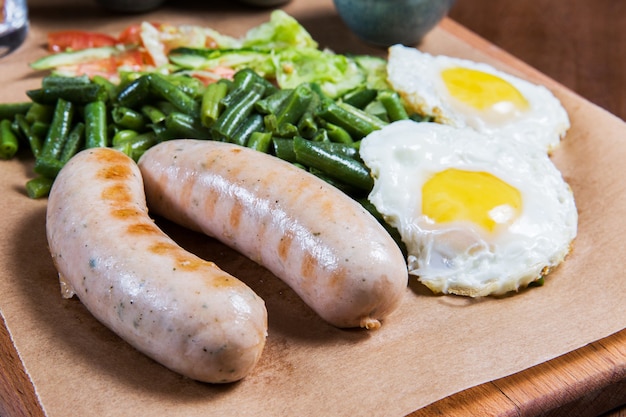 Omelette aux saucisses et légumes sur une table en bois. Gourmet. Petit déjeuner anglais