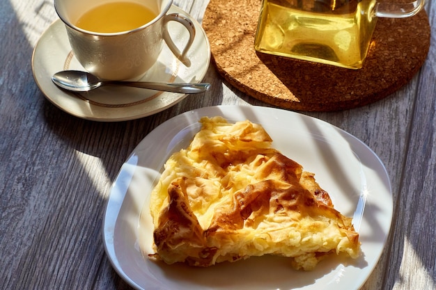 Une omelette dans une assiette sur une table en bois une théière et une tasse