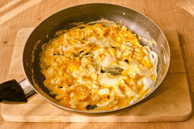 Omelette dans une poêle à frire sur un comptoir de cuisine en bois.