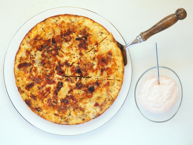 Omelette espagnole aux pommes de terre, tomates séchées, oignons et sauce aïoli