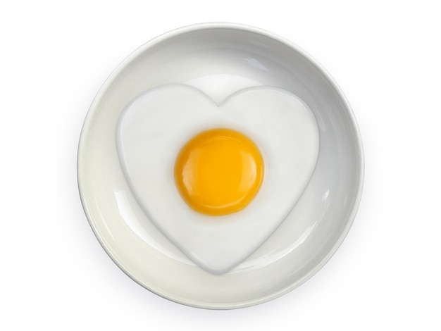 Omelette en forme de coeur oeuf au plat sur des plaques en céramique isolé sur fond blanc