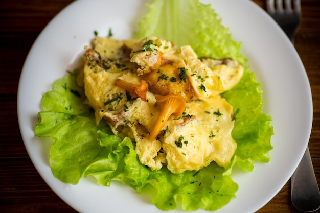 Omelette frite aux chanterelles de champignons forestiers sur une table en bois