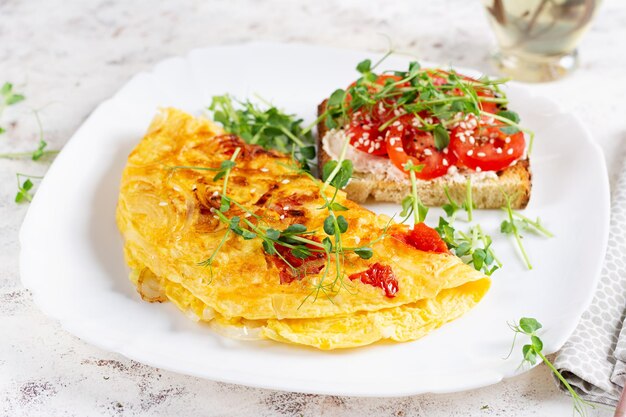 Photo omelette avec fromage et toast avec tomates sur assiette blanche frittata omelette italienne