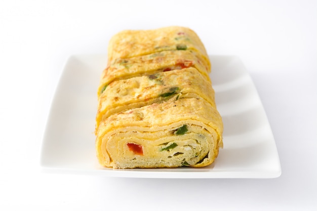 Omelette japonaise tamagoyaki traditionnelle isolée sur une surface blanche