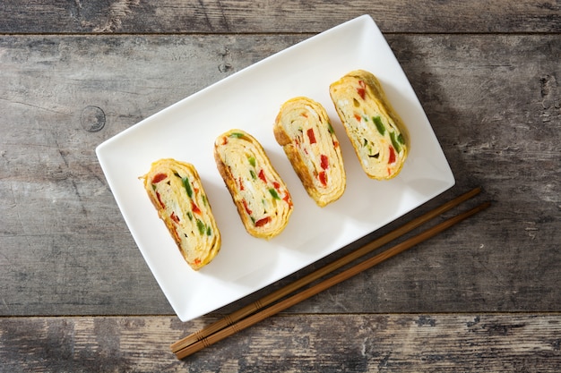 Photo omelette japonaise tamagoyaki traditionnelle sur table en bois