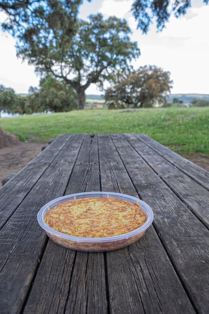 Omelette tortilla espagnole aux pommes de terre sur une plaque en plastique sur une table en bois avec fond naturel Plat traditionnel d'Espagne Tortilla de patatas pour le déjeuner ou une collation