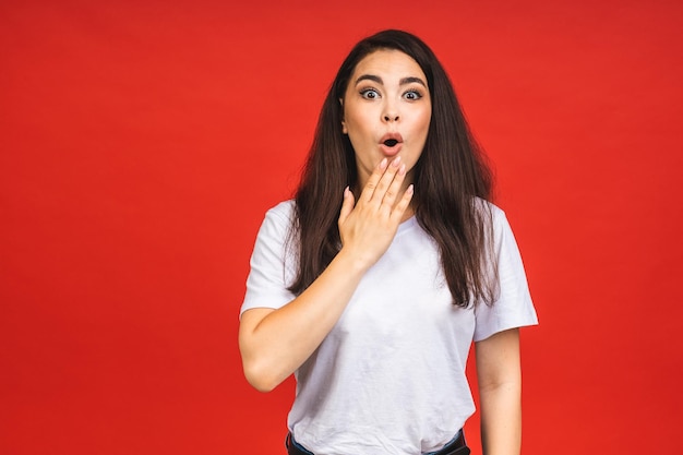 OMG Portrait d'une jeune femme étonnée et choquée isolée sur fond rouge