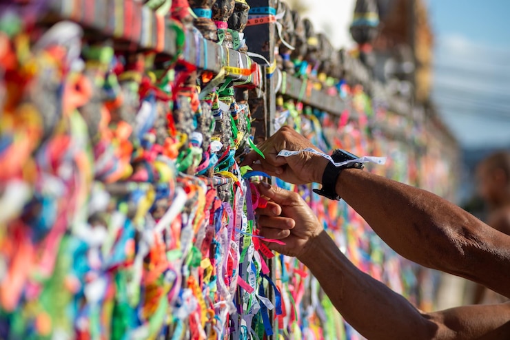 Photo on voit un fidèle catholique attacher un ruban souvenir à la balustrade de l'église senhor do bonfim dans la ville de salvador bahia