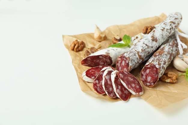 Ã Â¡oncept de nourriture savoureuse avec des saucisses de salami sur fond blanc