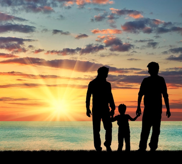 oncept de parents homosexuels. Silhouette de parents d'homosexuels et bébé marchant près de la mer au coucher du soleil