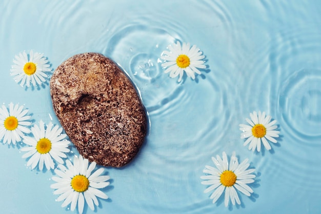 Ondulation de l'eau avec des fleurs. Arrière-plan tendance pour la présentation de produits cosmétiques. Conception artistique.