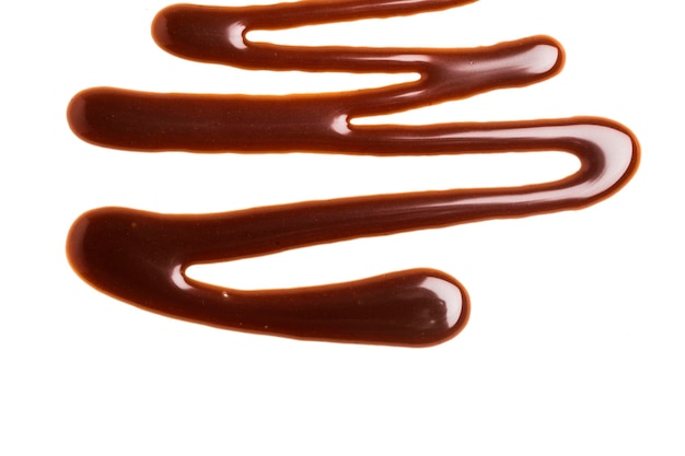 Ondulation de la sauce au caramel au chocolat sur un fond blanc uni