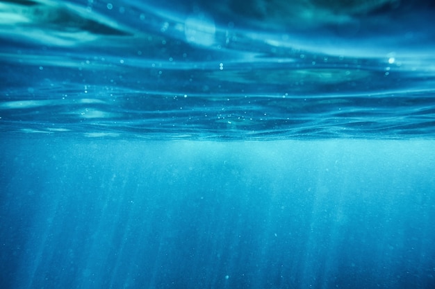 Ondulation de surface océan bleu sous-marin avec rayon de soleil en fond de mer tropicale